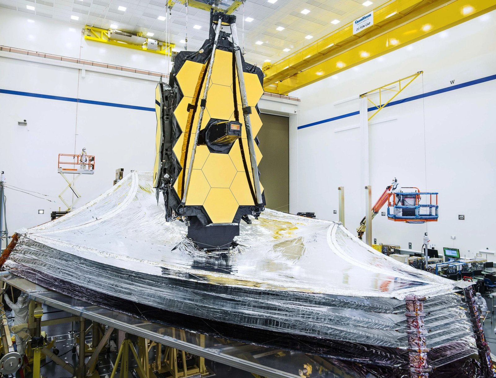 Webb's gold mirror above its deployed silver sunshield inside a clean room.